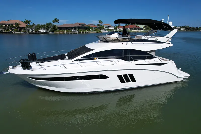 Slide: The Image of 2014 Sea Ray 510 Fly yacht on calm water, showcasing sleek design and luxury features. - 59