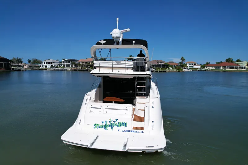 Slide: The Image of 2014 Sea Ray 510 Fly yacht cruising on a serene waterway, surrounded by waterfront homes. - 58