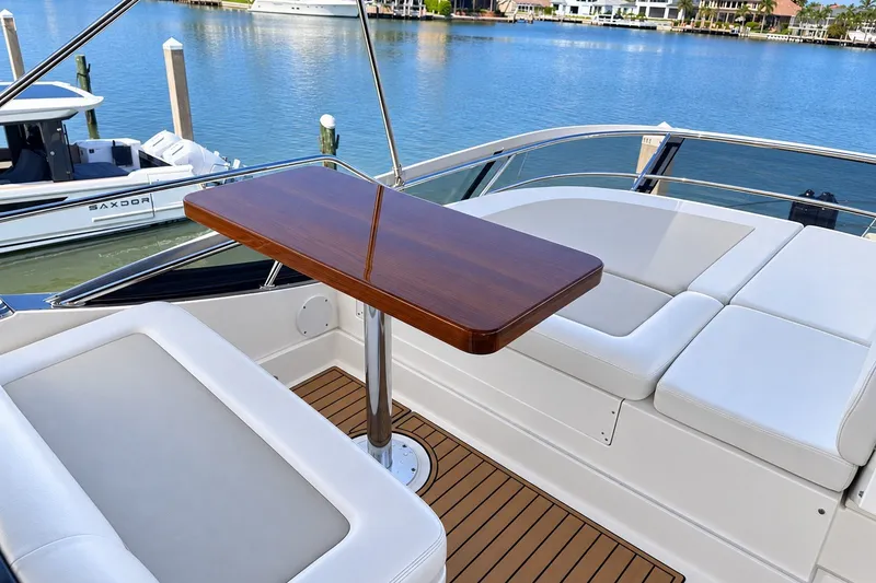 Slide: The Image of Luxurious seating area on 2014 Sea Ray 510 Fly yacht with wooden table, docked by the water. - 40