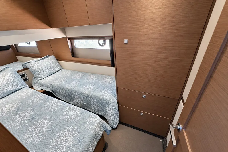 Slide: The Image of Twin beds in a 2014 Sea Ray 510 Fly yacht cabin with wood paneling. - 36