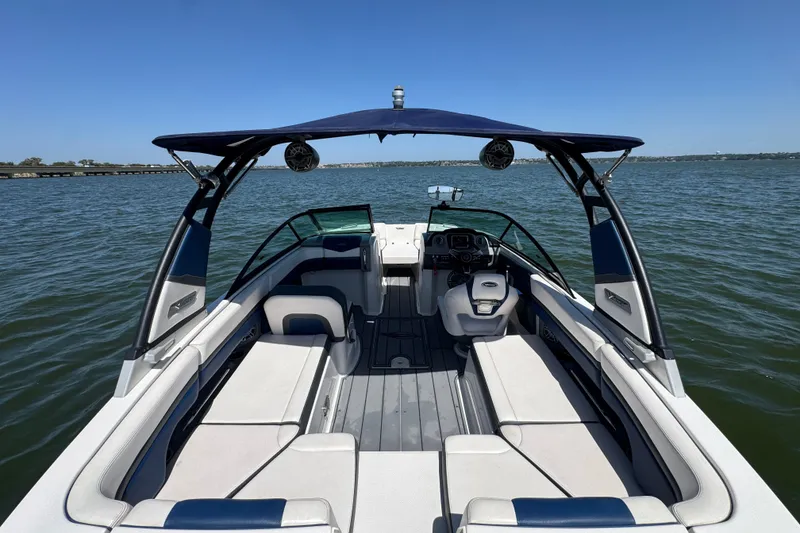 Slide: The Image of 2020 Chaparral Vortex 223 VRX boat interior with seating, canopy, and steering wheel on open water. - 25