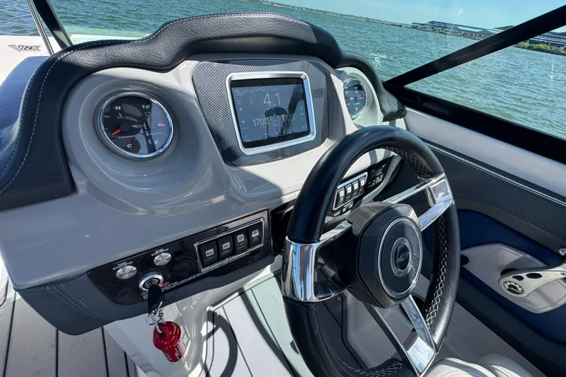 Slide: The Image of 2020 Chaparral Vortex 223 VRX dashboard with steering wheel and gauges, overlooking water. - 19