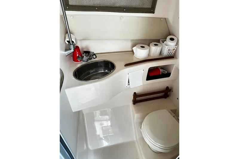 Slide: The Image of 2007 Grady-White Express 305 boat bathroom with sink, toilet, and storage shelves. - 20