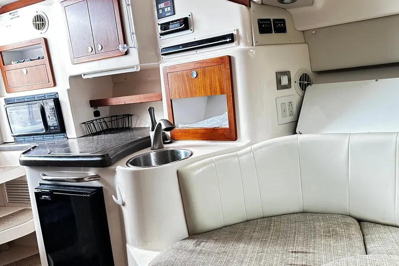 Slide: The Image of 2007 Grady-White Express 305 boat interior with kitchenette, sink, and seating area. - 18
