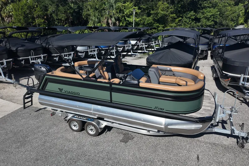 The Image of 2027 Viaggio x20u pontoon boat on trailer, surrounded by other boats, in a sunny outdoor setting. - 0