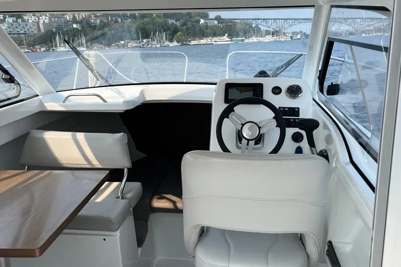 Slide: The Image of Interior of 2023 Beneteau Antares 7 boat with steering wheel and seating area. - 15