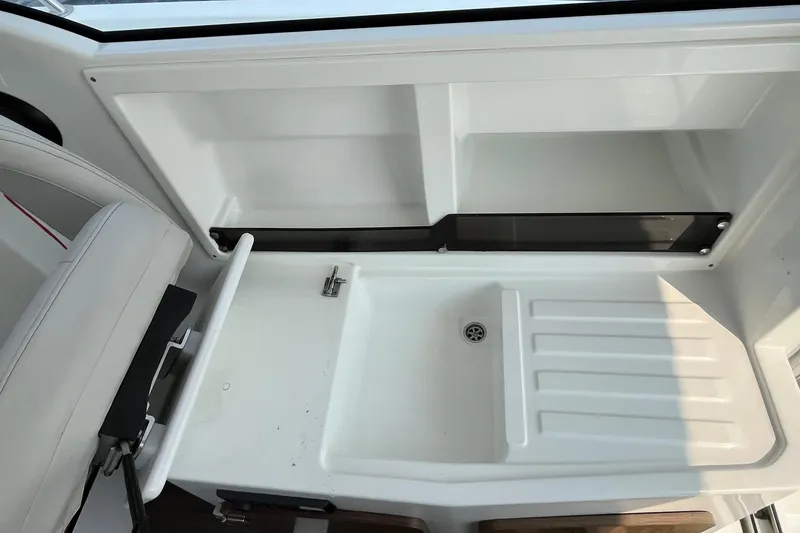 Slide: The Image of Interior view of 2023 Beneteau Antares 7 boat, featuring a white sink and storage area. - 20