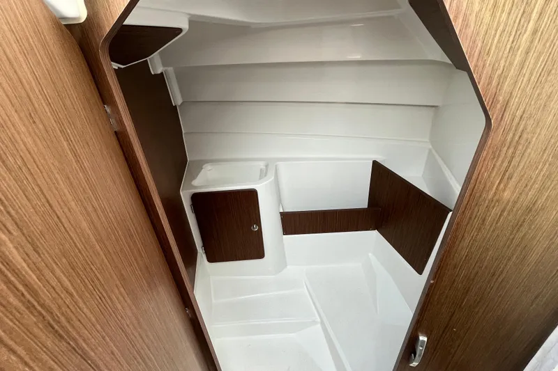 Slide: The Image of Interior cabin of 2023 Beneteau Antares 7 boat, featuring wood accents and compact design. - 19