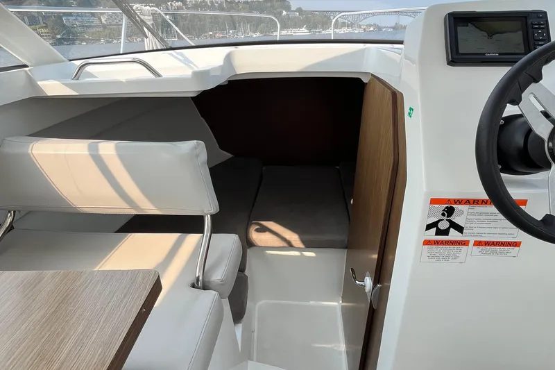 Slide: The Image of Interior view of 2023 Beneteau Antares 7 boat, featuring seating and navigation area. - 18