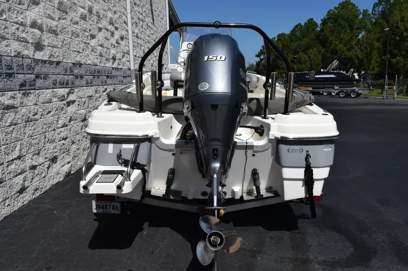 Slide: The Image of 2021 NauticStar 211 Hybrid boat with powerful outboard motor, parked outdoors. - 4