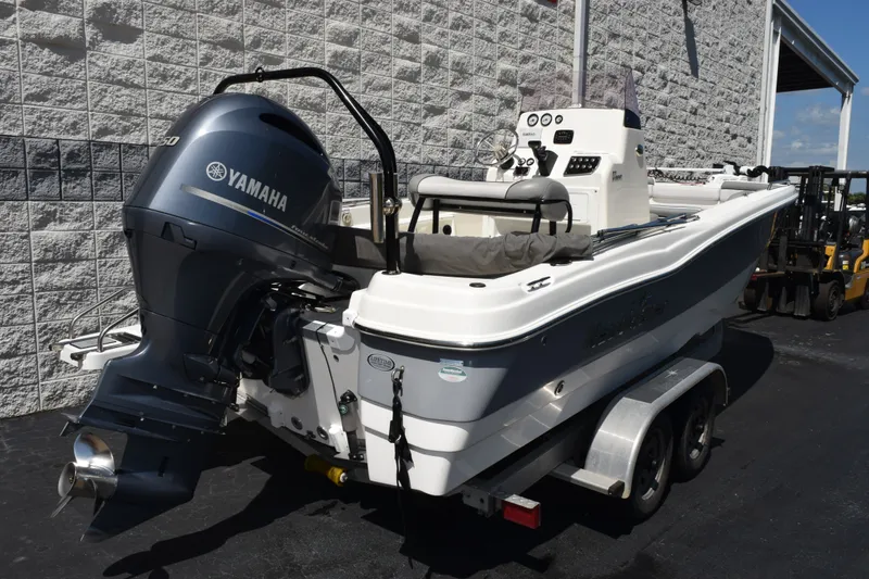 Slide: The Image of 2021 NauticStar 211 Hybrid boat with Yamaha engine on trailer, parked outdoors. - 3