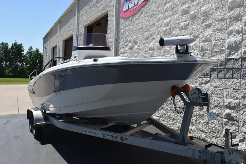 Slide: The Image of 2021 NauticStar 211 Hybrid boat on trailer outside a building. - 2
