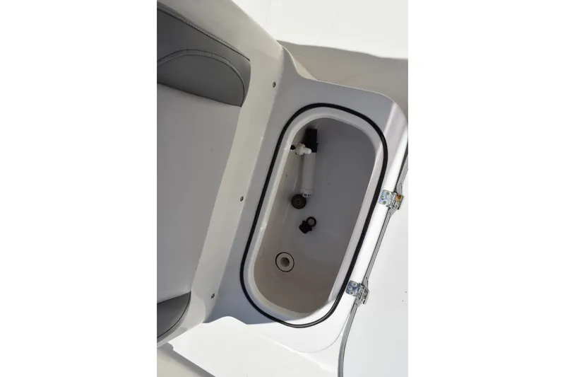 Slide: The Image of 2021 NauticStar 211 Hybrid boat storage compartment with open lid and visible fittings. - 11