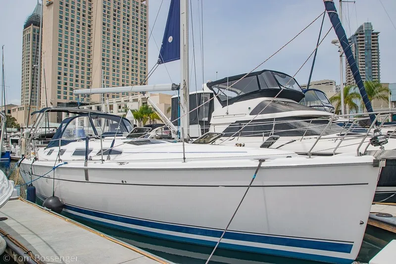 Slide: The Image of 2007 Hunter 41 Aft Cockpit sailboat docked in a marina with cityscape background. - 4