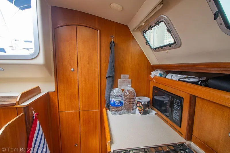 Slide: The Image of Interior of 2007 Hunter 41 Aft Cockpit sailboat kitchen with wood cabinetry and appliances. - 15