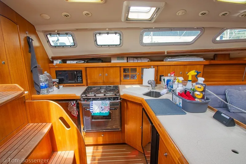 Slide: The Image of Interior of 2007 Hunter 41 Aft Cockpit yacht kitchen with wooden cabinetry and appliances. - 12