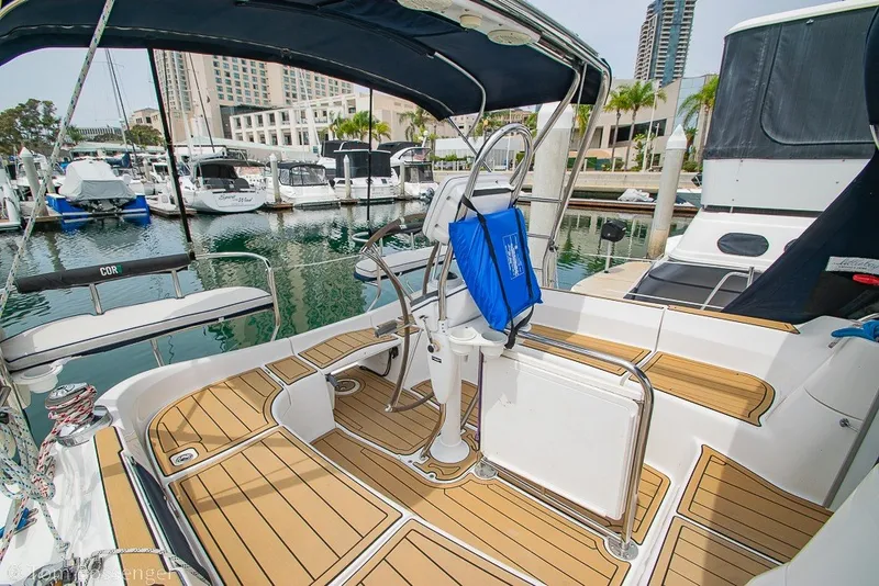 Slide: The Image of Aft cockpit of 2007 Hunter 41 sailboat docked in marina, featuring teak flooring and helm. - 7