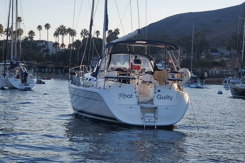 Slide: The Image of Hunter 41 Aft Cockpit sailboat, 2007 model, anchored in scenic harbor with palm trees. - 37