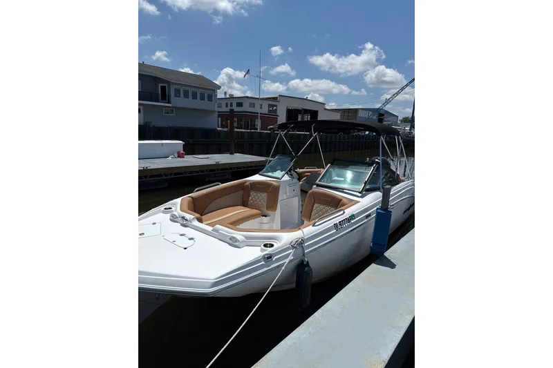 The Image of 2025 NauticStar 223 DC Deck boat docked, featuring sleek design and comfortable seating. - 1