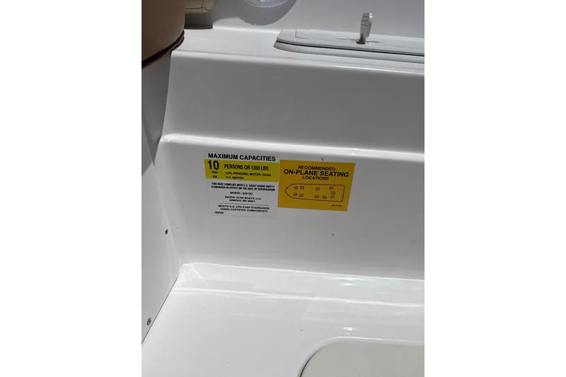 Slide: The Image of 2025 NauticStar 223 DC Deck boat capacity label, seating for 10 people or 1350 lbs. - 9