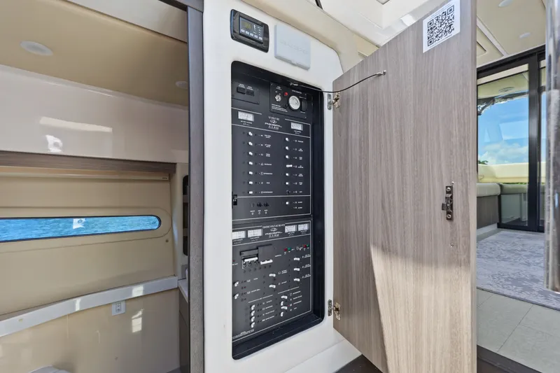 Slide: The Image of Electrical panel inside a 2021 Regal 38 XO yacht, with open cabinet door. - 34