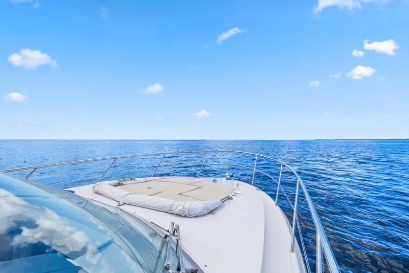 Slide: The Image of 2021 Regal 38 XO yacht cruising on open blue sea under clear sky. - 43