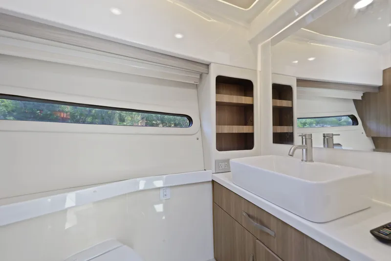 Slide: The Image of Modern bathroom interior of 2021 Regal 38 XO yacht with sleek sink and wooden cabinetry. - 38