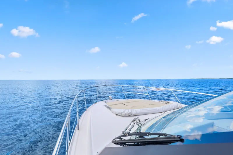 Slide: The Image of 2021 Regal 38 XO yacht cruising on open blue sea under clear sky. - 41