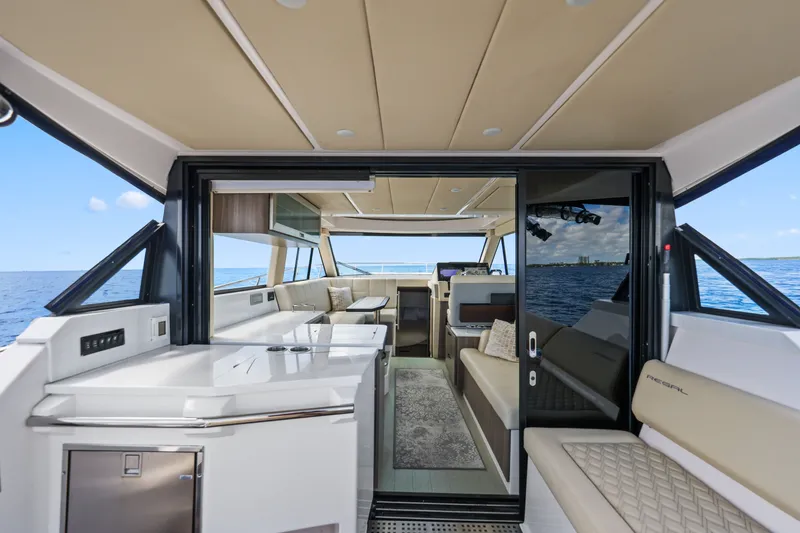 Slide: The Image of Interior view of 2021 Regal 38 XO yacht with luxurious seating and ocean backdrop. - 18