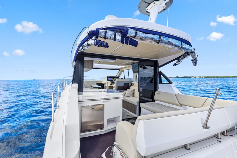 Slide: The Image of 2021 Regal 38 XO yacht interior with luxurious seating, open sea view, and modern design. - 16