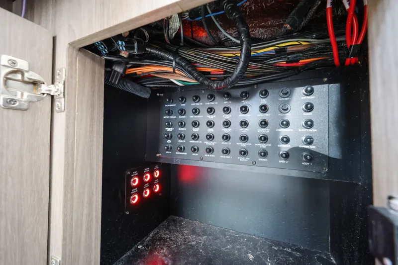 Slide: The Image of Electrical panel inside 2021 Regal 38 XO boat, showcasing wiring and switches. - 51
