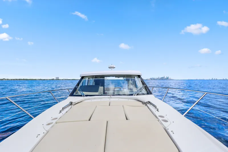 Slide: The Image of 2021 Regal 38 XO yacht cruising on open water under clear blue skies. - 42