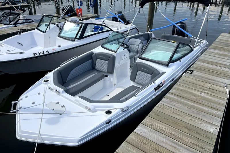 The Image of 2025 NauticStar 223 DC Deck boat docked, featuring sleek design and comfortable seating. - 1
