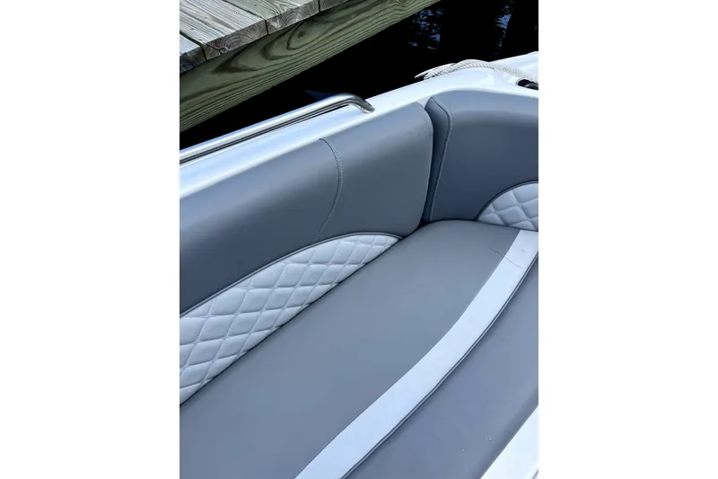 Slide: The Image of 2025 NauticStar 223 DC Deck boat with elegant gray seating and quilted accents. - 6