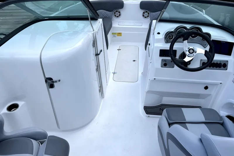 Slide: The Image of 2025 NauticStar 223 DC Deck boat interior with steering wheel and seating. - 4