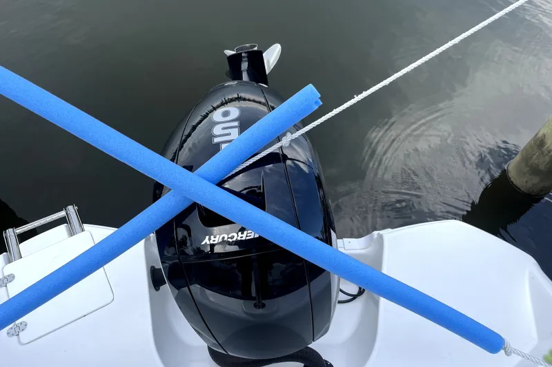 Slide: The Image of Outboard motor on 2025 NauticStar 223 DC Deck boat with blue pool noodles. - 9
