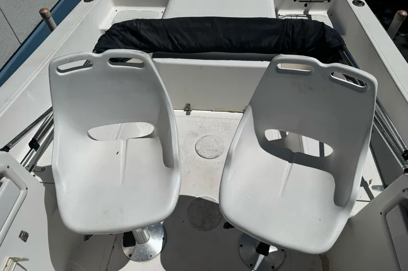 Slide: The Image of 2003 Seapro 190 WA boat interior with two white seats and a black cushion. - 16