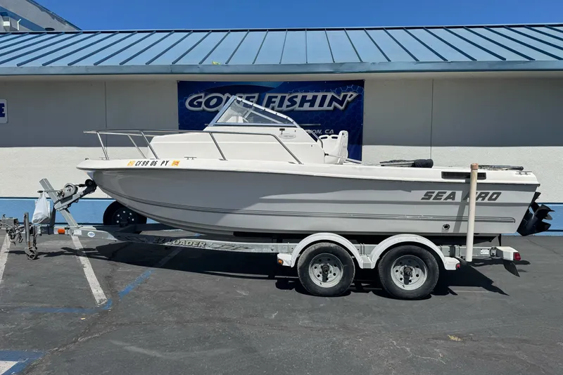 The Image of 2003 Seapro 190 WA boat on trailer, parked outside a building with blue roof. - 1
