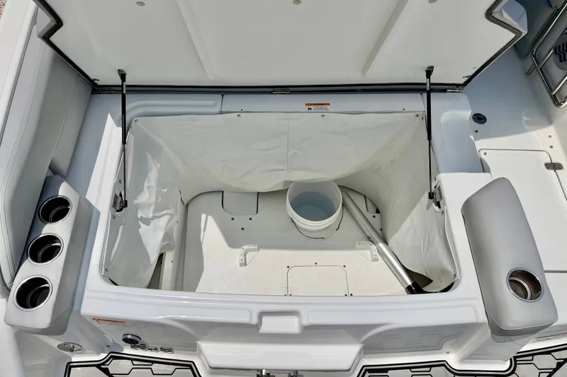 Slide: The Image of 2023 Four Winns HD8 OB boat storage compartment with open lid and cup holders. - 26