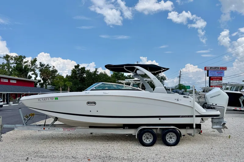 The Image of 2023 Four Winns HD8 OB boat on trailer, displayed outdoors under a clear sky. - 0