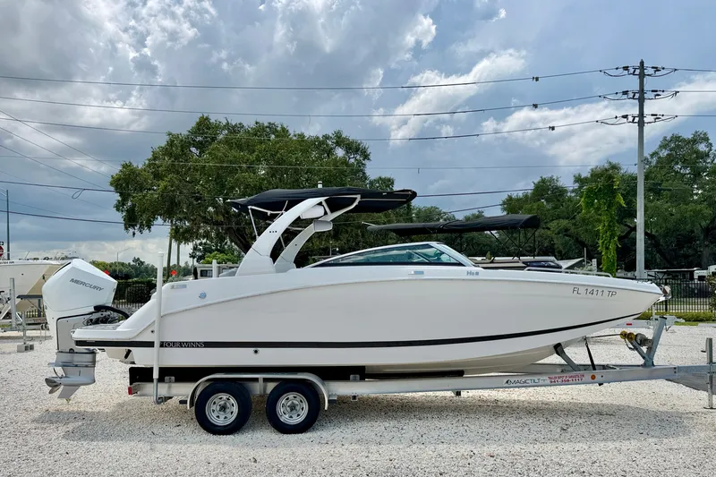 Slide: The Image of 2023 Four Winns HD8 OB boat on trailer, side view under cloudy sky. - 4