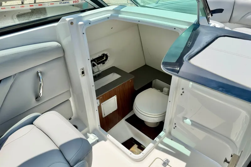 Slide: The Image of 2023 Four Winns HD8 OB boat interior with compact bathroom and seating area. - 18