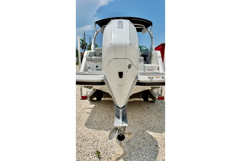 Slide: The Image of 2023 Four Winns HD8 OB boat rear view with outboard motor on gravel. - 39