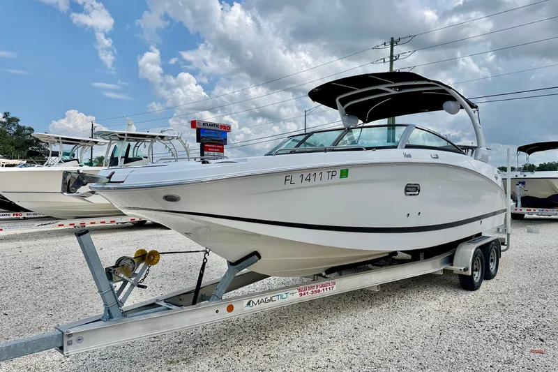Slide: The Image of 2023 Four Winns HD8 OB boat on trailer, displayed outdoors under cloudy sky. - 1