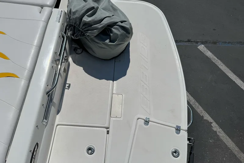 Slide: The Image of 2006 Ebbtide 2100 Bow Rider boat deck with cover, showing seating and storage. - 8