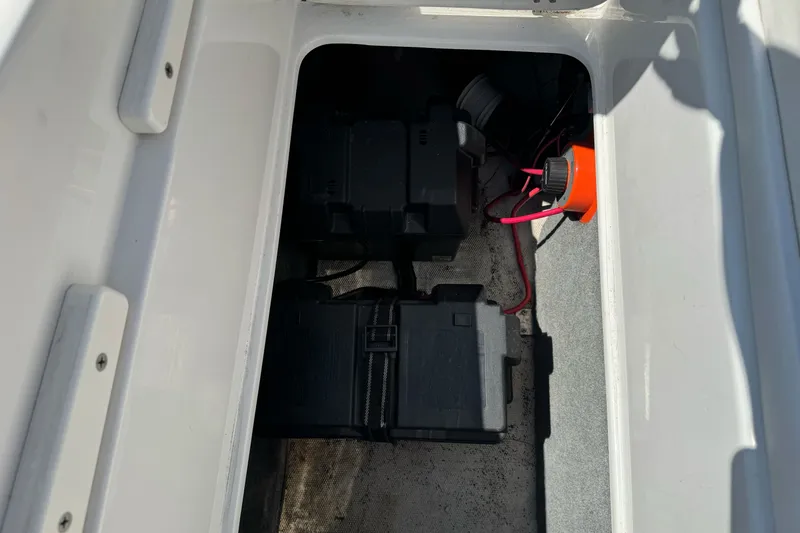 Slide: The Image of Battery compartment of a 2006 Ebbtide 2100 Bow Rider boat, featuring dual batteries. - 22