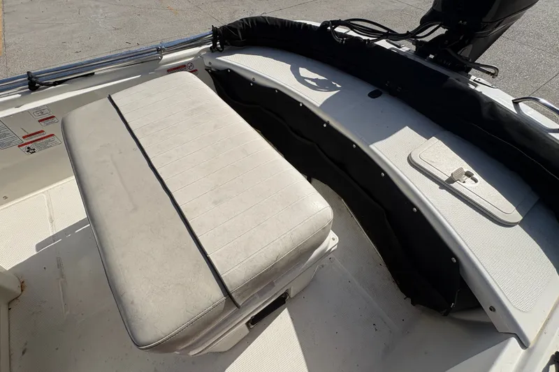 Slide: The Image of 2016 Mako Pro Skiff 17 CC boat interior with cushioned seating and storage compartment. - 16