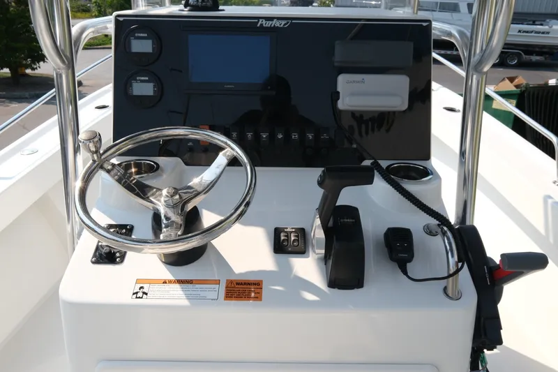 Slide: The Image of 2024 Parker 2100 Center Console boat dashboard with steering wheel and controls. - 9