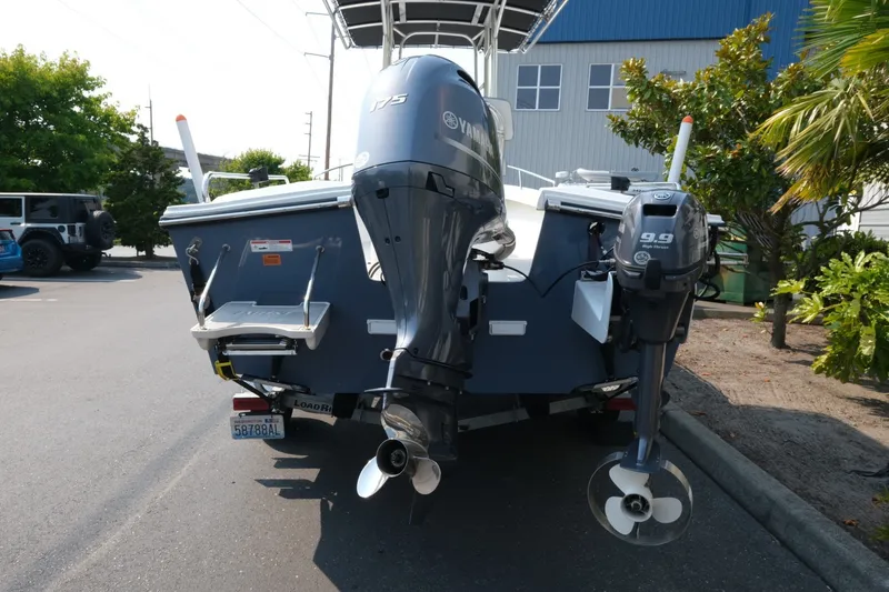 Slide: The Image of 2024 Parker 2100 Center Console boat with dual Yamaha outboard motors in a parking lot. - 5