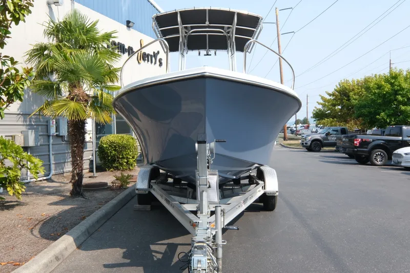 Slide: The Image of 2024 Parker 2100 Center Console boat on trailer, parked near palm trees and vehicles. - 3